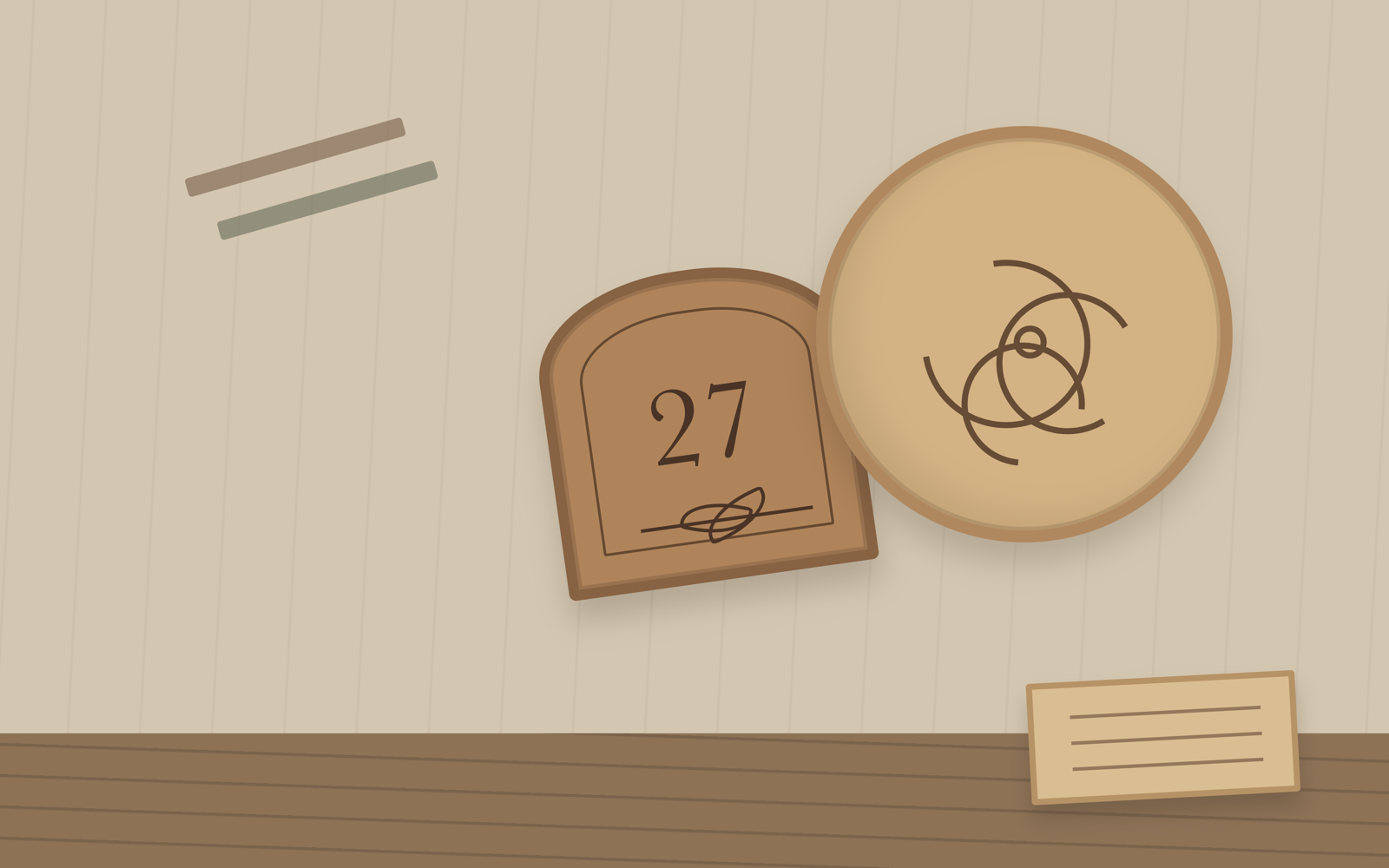 Engraved wooden pieces, drawing sheets, and workshop tools arranged on a pale workbench